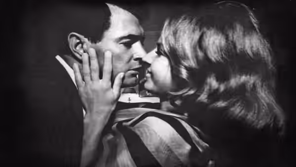 A man and woman kiss, her hands cupping his face