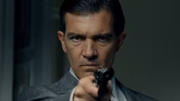Dr. Robert Ledgard (Antonio Banderas) aims a pistol directly ahead