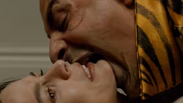 A man in a tiger-striped outfit presses his face against a woman's