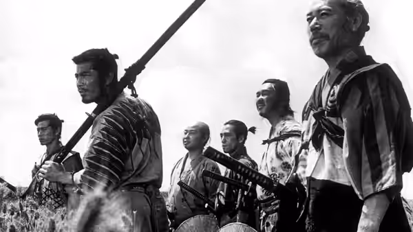 Several samurai stand side by side holding weapons and staring ahead