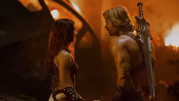 Teela (Camila Mendes) faces He-Man (Nicholas Galitzine) amid fiery ruins