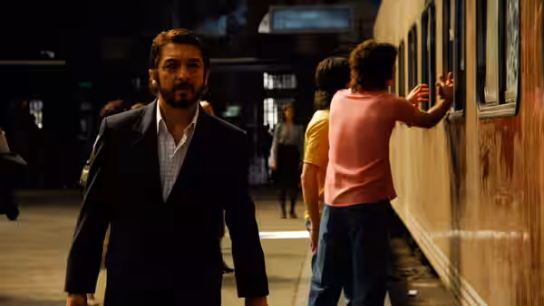 Benjamín Espósito (Ricardo Darín) stands on a train platform watching passengers