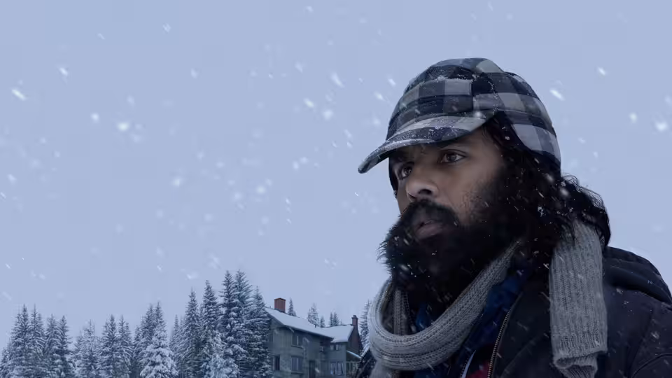 Jeevan Chaudhary (Himesh Patel) gazes upward amid falling snow in winter