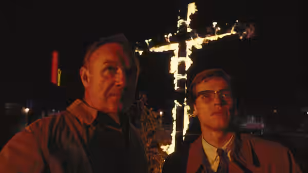 Rupert Anderson (Gene Hackman) and Alan Ward (Willem Dafoe) stand before a burning cross at night