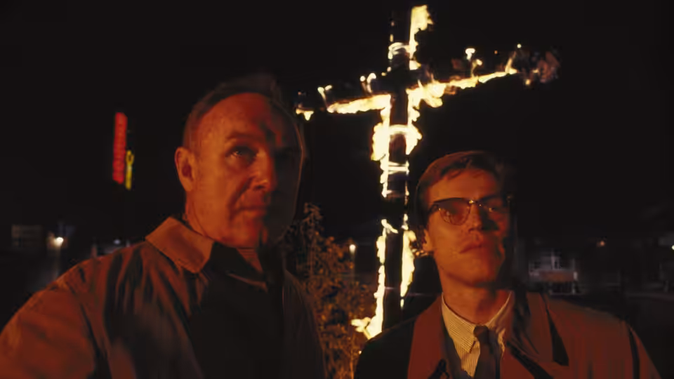Rupert Anderson (Gene Hackman) and Alan Ward (Willem Dafoe) stand before a burning cross at night
