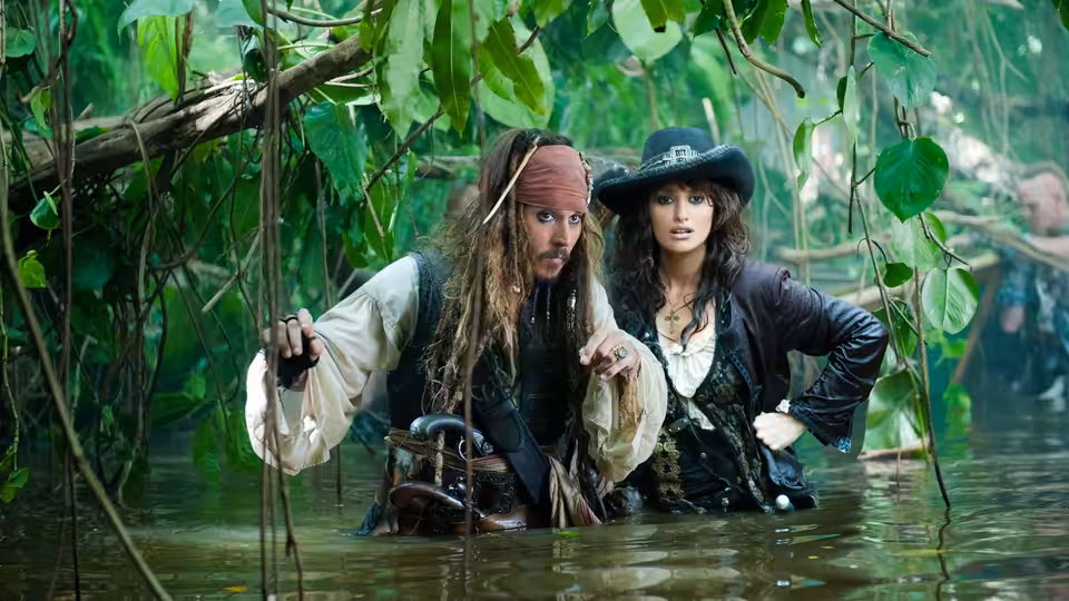 Jack Sparrow (Johnny Depp) and Angelica (Penélope Cruz) wading through a vine-filled jungle river