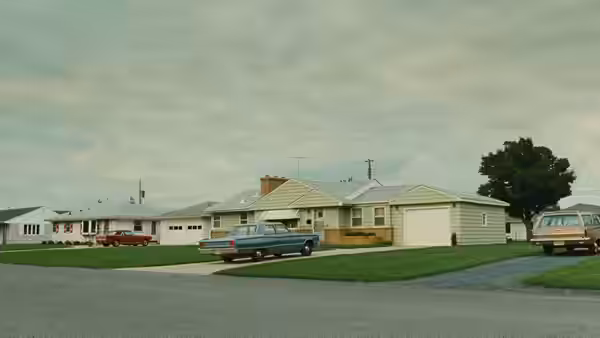 A quiet suburban street lined with houses and parked cars