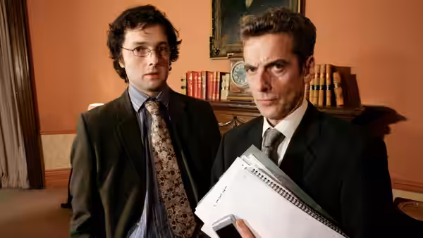 Malcolm Tucker (Peter Capaldi) and colleague holding papers in office