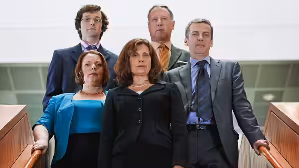 Group of politicians standing together on indoor stairs looking ahead