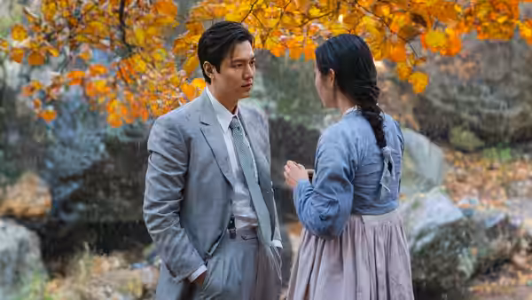 Hansu (Lee Min-ho) facing Sunja (Kim Min-ha) among autumn trees and rocks