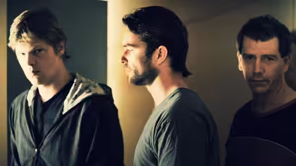 J (James Frecheville) standing with Craig and Pope in profile