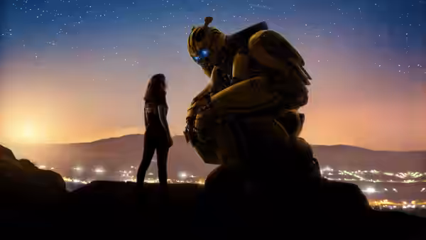 Charlie Watson (Hailee Steinfeld) stands beside Bumblebee on a hill beneath the stars