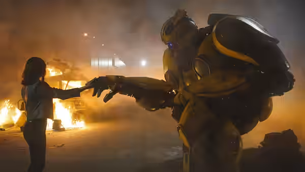 Charlie Watson (Hailee Steinfeld) reaches for Bumblebee's hand amid flames and smoke