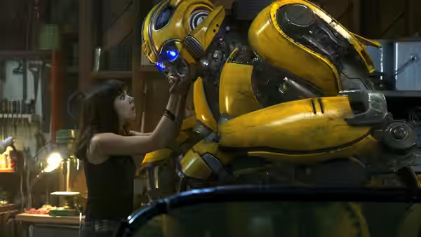 Charlie Watson (Hailee Steinfeld) reaches up to touch Bumblebee in a workshop