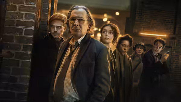 Jackson Lamb (Gary Oldman) leading his team through a brick corridor