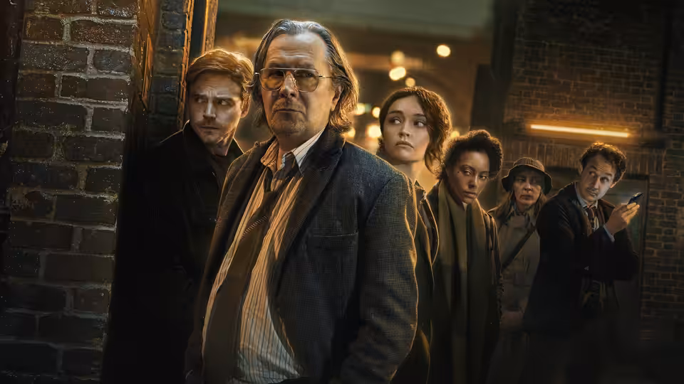 Jackson Lamb (Gary Oldman) leading his team through a brick corridor