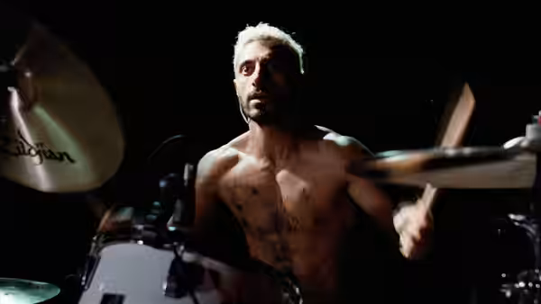 Ruben Stone (Riz Ahmed) plays drums shirtless on a darkened stage