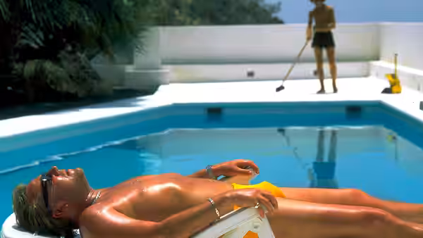 Gal (Ray Winstone) lying poolside while a man cleans in the background