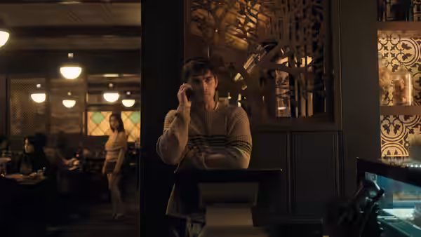 Bear (Michael Johnston) talks on his phone in a restaurant