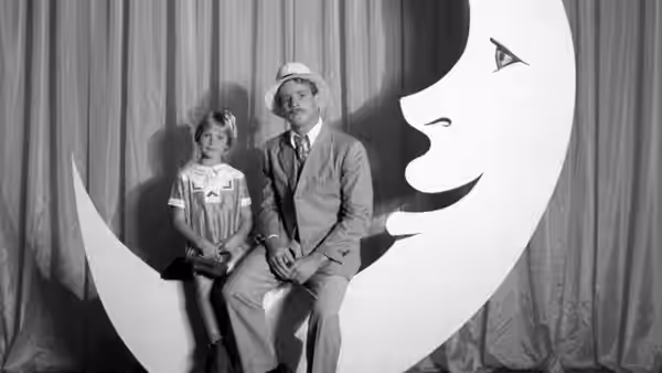Addie Loggins (Tatum O'Neal) and Moses Pray (Ryan O'Neal) pose on a crescent moon stage prop