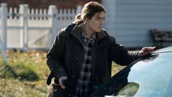 Mare Sheehan (Kate Winslet) stands by a car with her hand on the hood