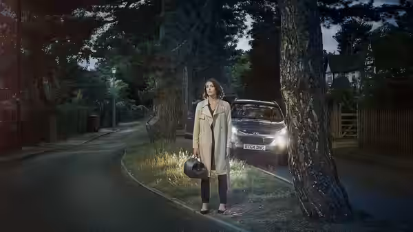 Dr Gemma Foster (Suranne Jones) stands on a suburban street holding a helmet