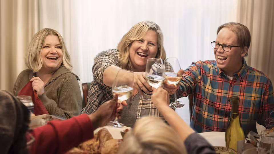 Sam Miller (Bridget Everett) and friends toasting with wine at dinner