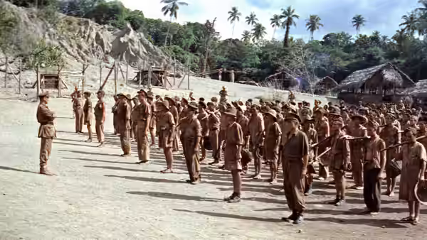 Company of soldiers assembled in formation at a jungle camp