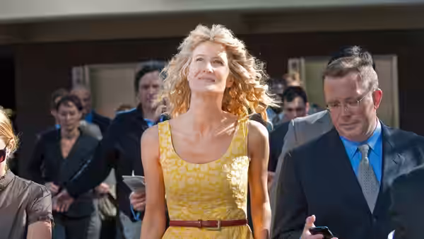 Amy Jellicoe (Laura Dern) in a yellow dress looking upwards outdoors
