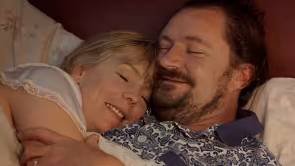 Wendy (Alison Steadman) and Andy (Jim Broadbent) lie together in bed smiling