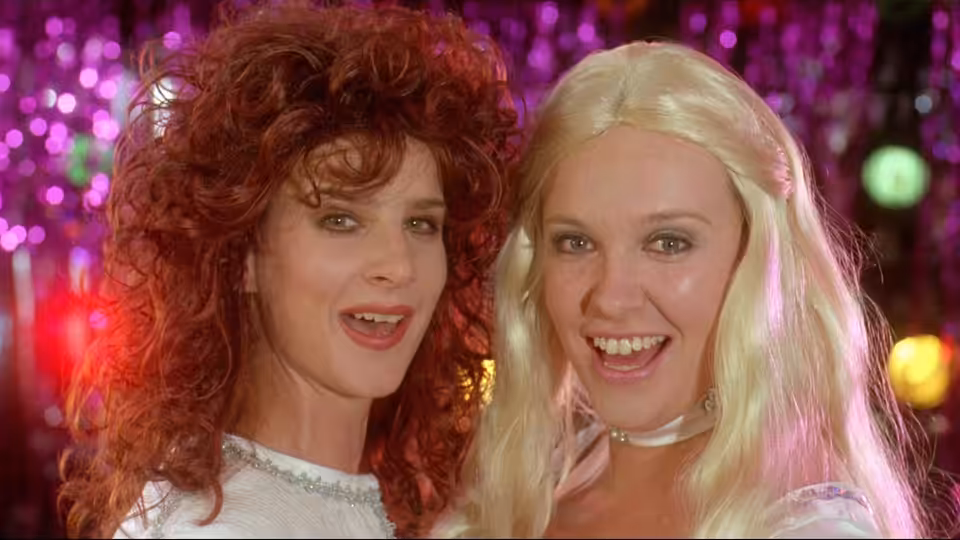 Rhonda (Rachel Griffiths) and Muriel (Toni Collette) smiling together at a nightclub