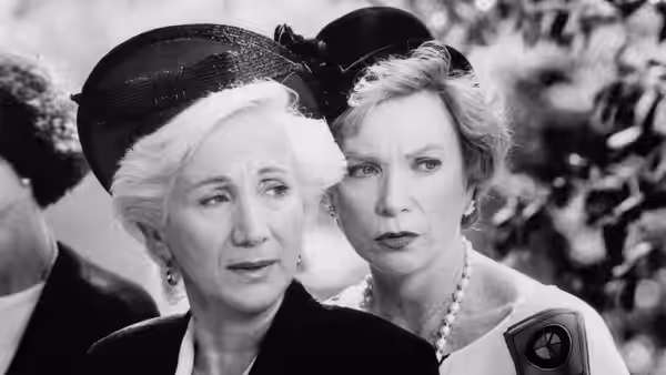 Clairee Belcher (Olympia Dukakis) and M'Lynn Eatenton (Sally Field) stand together at an outdoor gathering