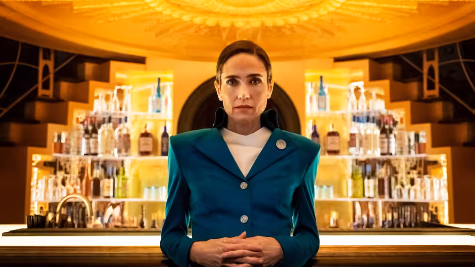 Melanie Cavill (Jennifer Connelly) stands with clasped hands at a bar