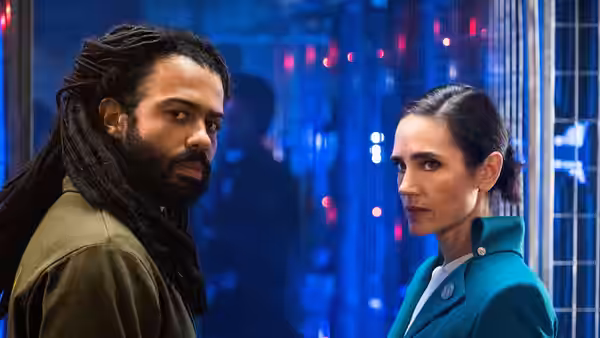 Andre Layton (Daveed Diggs) and Melanie Cavill (Jennifer Connelly) stand close together indoors