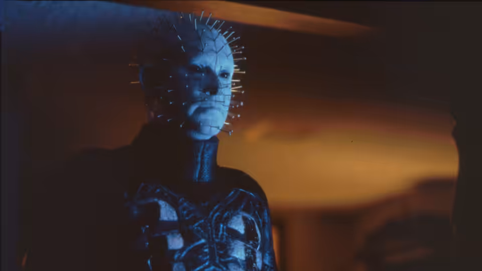 Pinhead (Doug Bradley) standing in a dimly lit interior