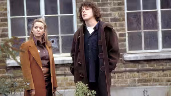 Jonathan Creek (Alan Davies) standing beside a woman outside a brick building