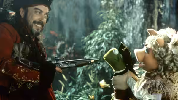 Long John Silver (Tim Curry) pointing a pistol at Kermit and Miss Piggy