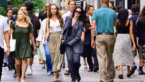 Miranda Priestly (Meryl Streep) striding along a crowded city sidewalk with colleagues