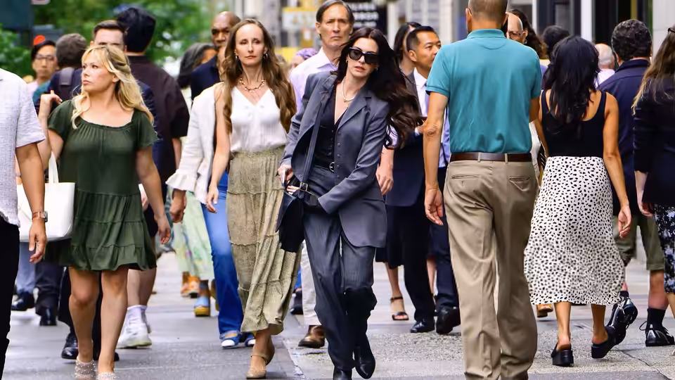 Miranda Priestly (Meryl Streep) striding along a crowded city sidewalk with colleagues