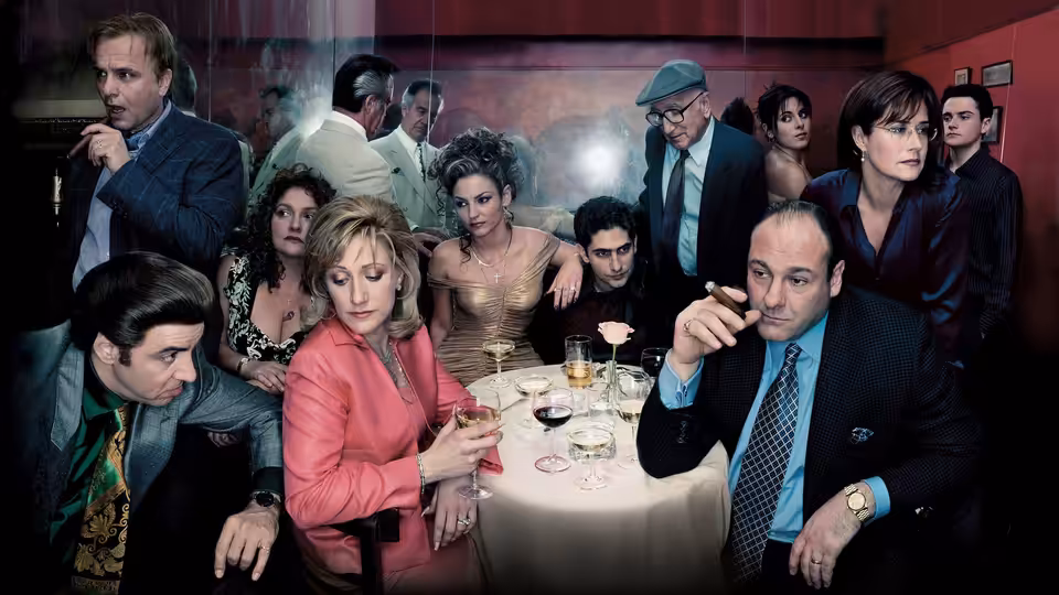 Tony Soprano (James Gandolfini) sits at a restaurant table among formally dressed guests