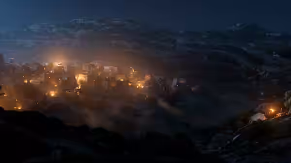 Lights glow in fog-covered mountain village at night