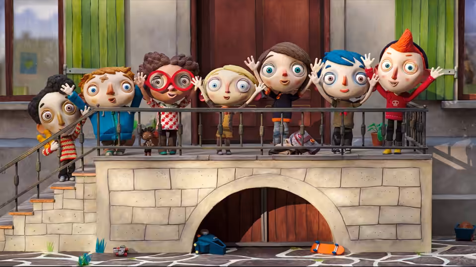Children waving from behind a railing above a stone archway