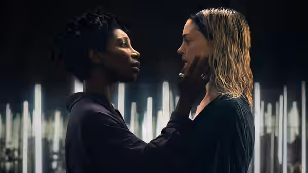 Sam Anselm (Michaela Coel) touches Hilda Offer's (Hunter Schafer) face closely