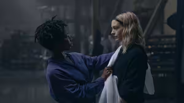 Sam Anselm (Michaela Coel) adjusts Hilda Offer's (Hunter Schafer) garment in a workshop