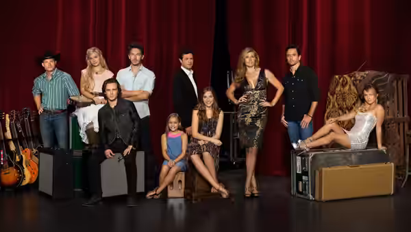 Nashville cast gathers on a stage with guitars and red curtains