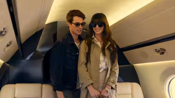 Solène (Anne Hathaway) and Hayes (Nicholas Galitzine) seated together inside a private jet cabin