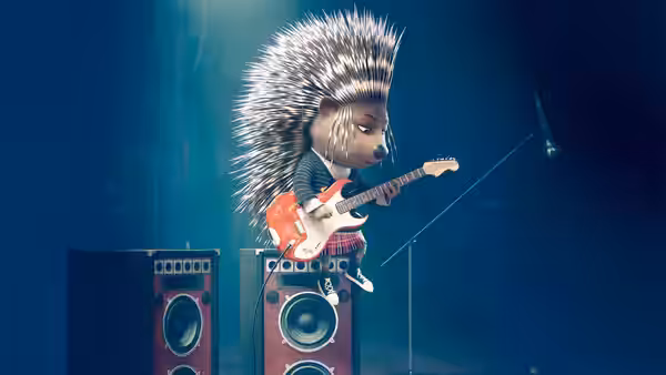 Ash (Scarlett Johansson) playing an electric guitar atop large speakers on stage