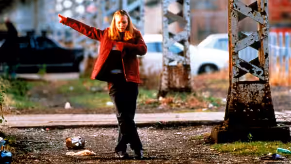 Sara Johnson (Julia Stiles) stands outside with arm extended pointing forward