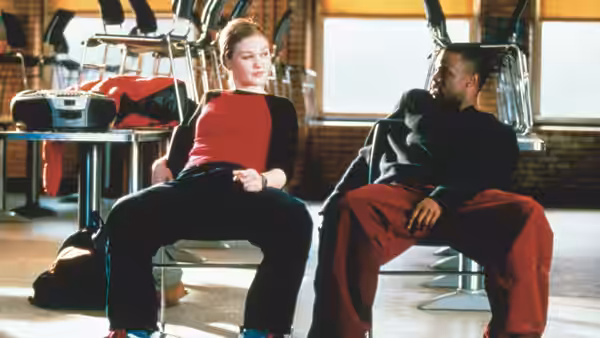 Sara Johnson (Julia Stiles) and Derek Reynolds (Sean Patrick Thomas) sit together on chairs
