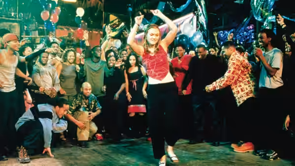 Sara Johnson (Julia Stiles) dances with arms raised in a crowded nightclub